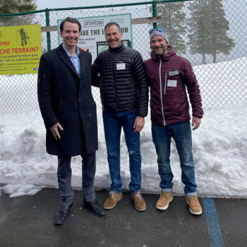 Three men standing outside in parking lot in snow. Left to right- Kiley, Bullock, Polivy. 