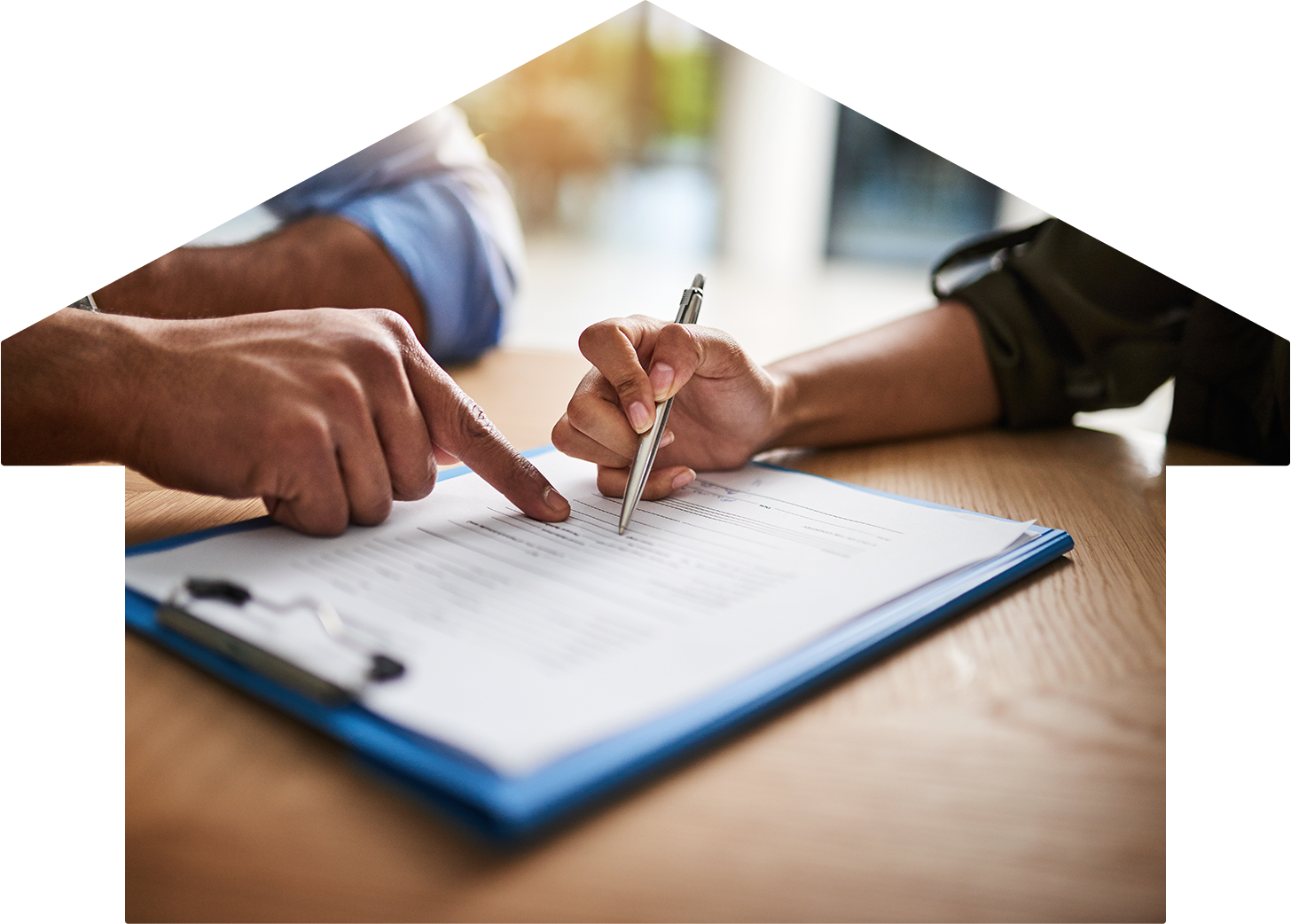 Two hands prepare to sign paperwork