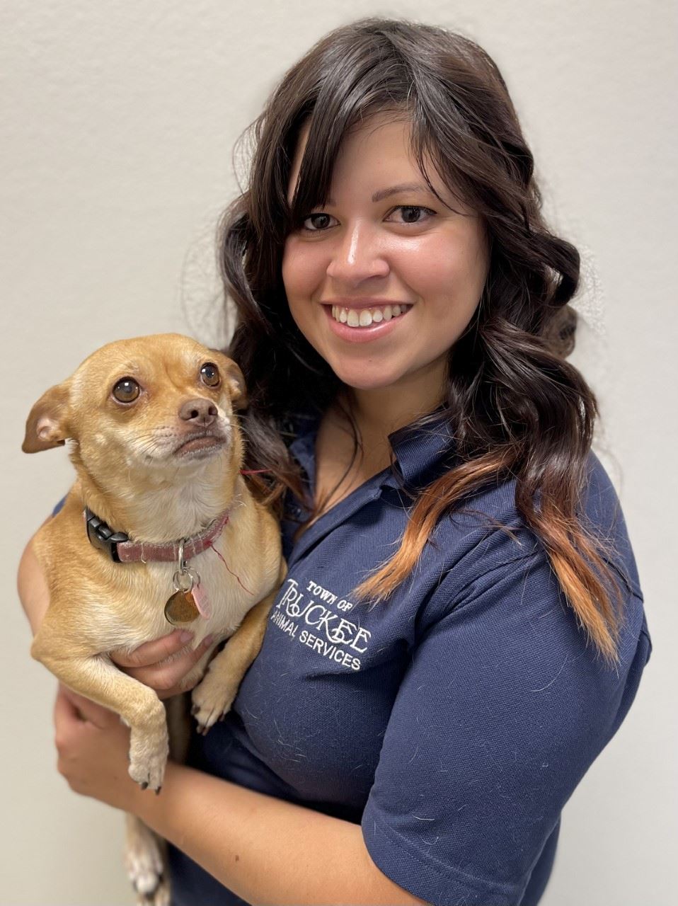 Women holding a small dog. 