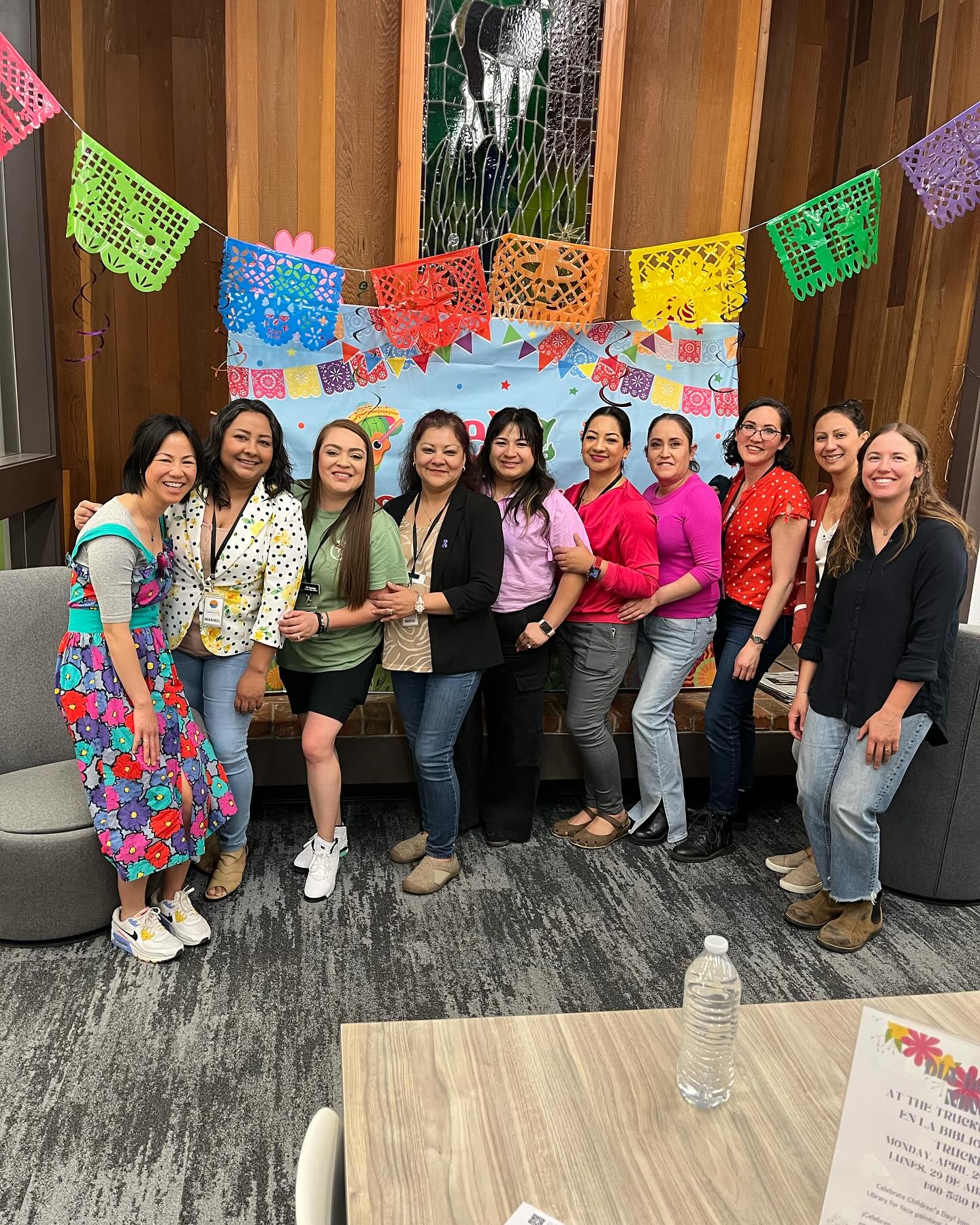 Group of women standing in a line smiling at the camera. 