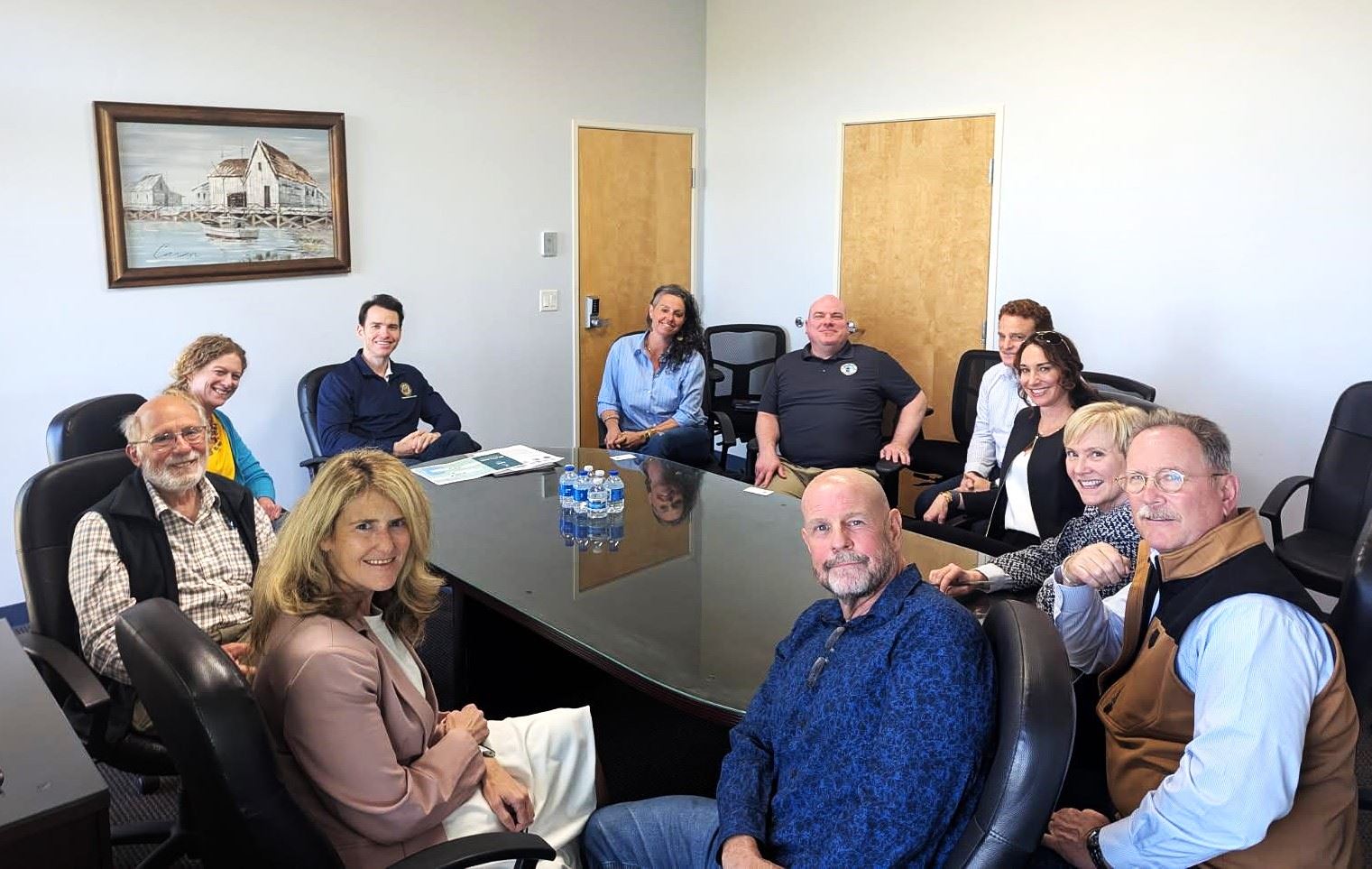 Group of people sitting around a table in an office space or conference room. 