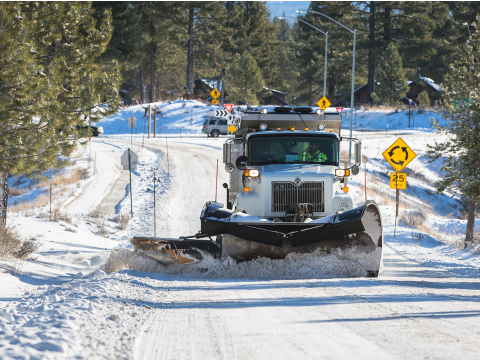 Snow Plow Clearing the Street near a Roundabout
